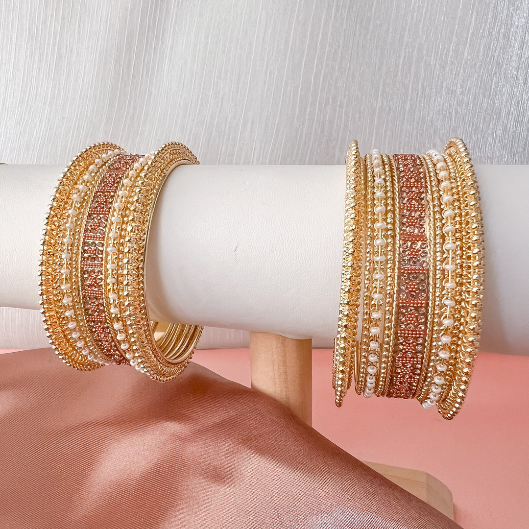Goudkleurige armbanden met oranje kralen